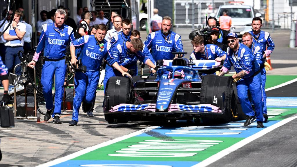 Fernando Alonso siendo remolcado por sus mecánicos.