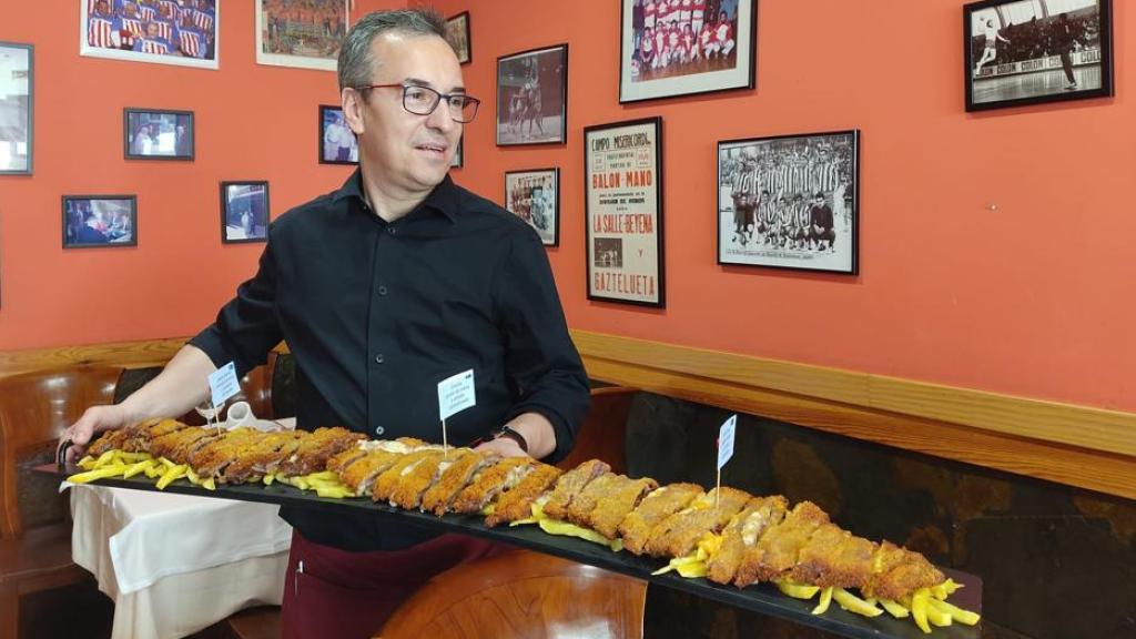 Tito, el propietario del restaurante, sujetando el cachopo de un metro.