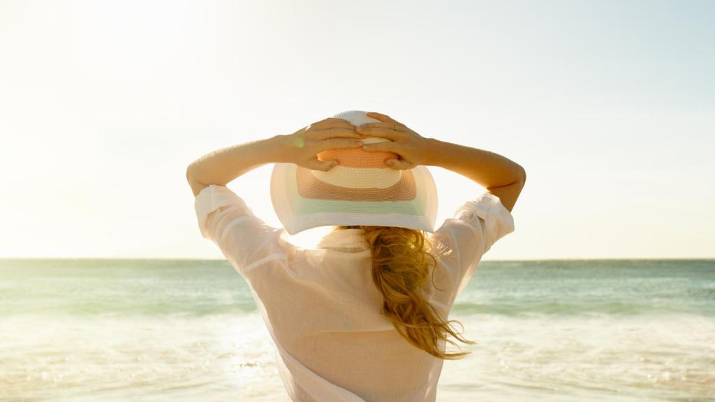 Mujer mirando hacia el mar en la playa