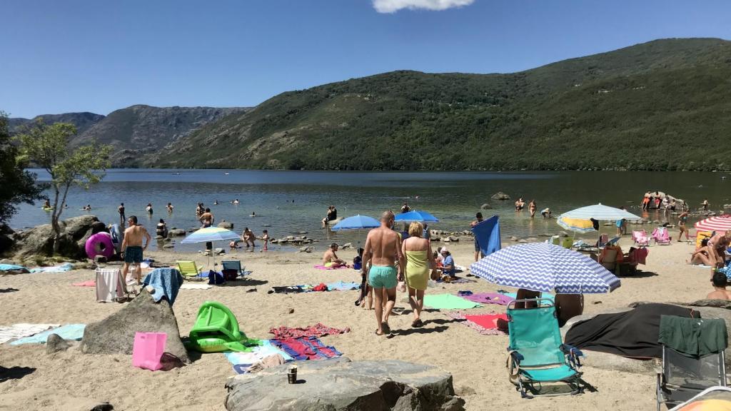 Un grupo de turistas toman el sol en una de las playas del Lago de Sanabria, Zamora