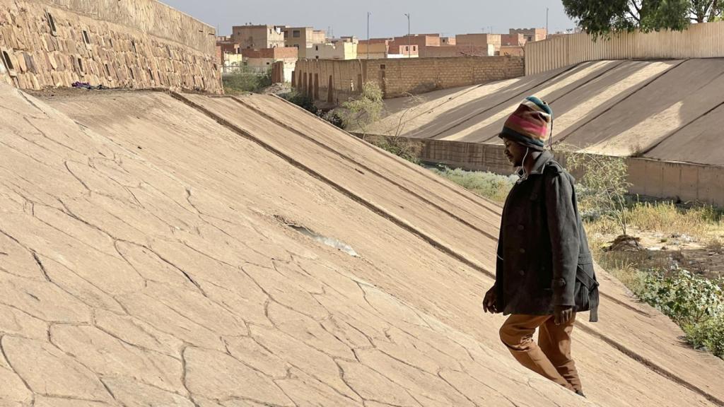 Nassir, un sudanés de 18 años, sube por el cauce seco del puente donde duerme cada noche en la ciudad marroquí de Oujda.