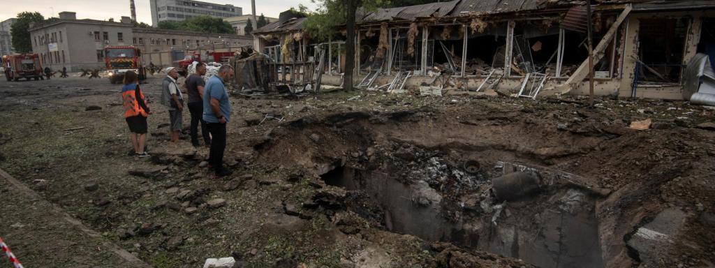 Varios ucranianos observan un cráter provocado por un misil ruso en Dnipro, este viernes 15 de julio