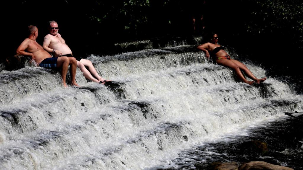 Británicos haciendo frente a la ola de calor en el río Derwent este martes.