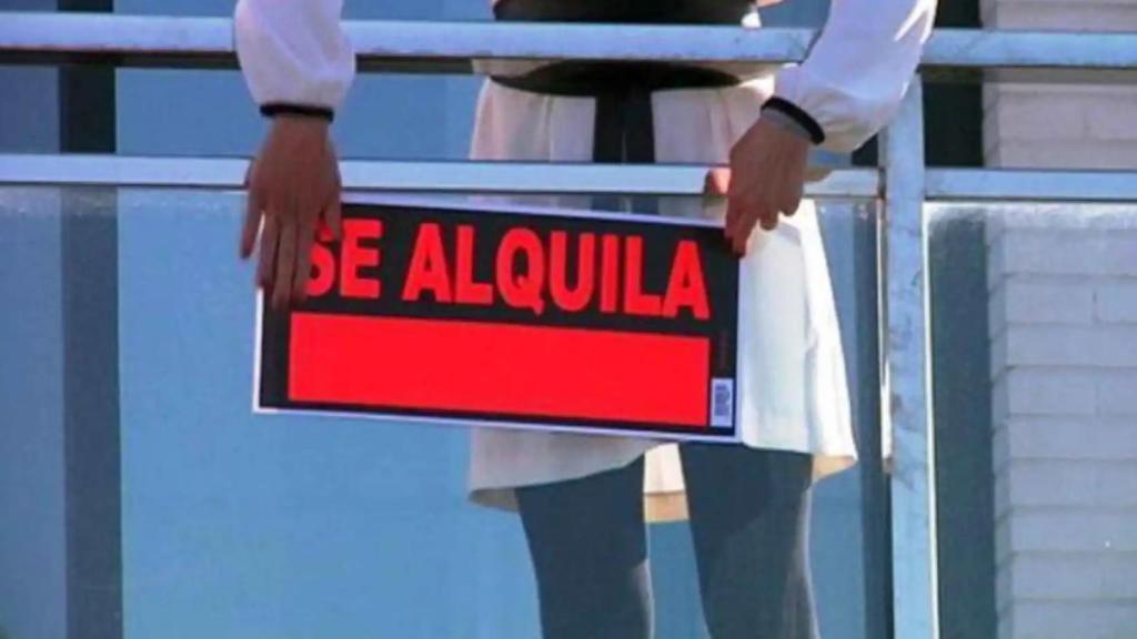 Un propietario coloca un cartel para alquilar su vivienda.