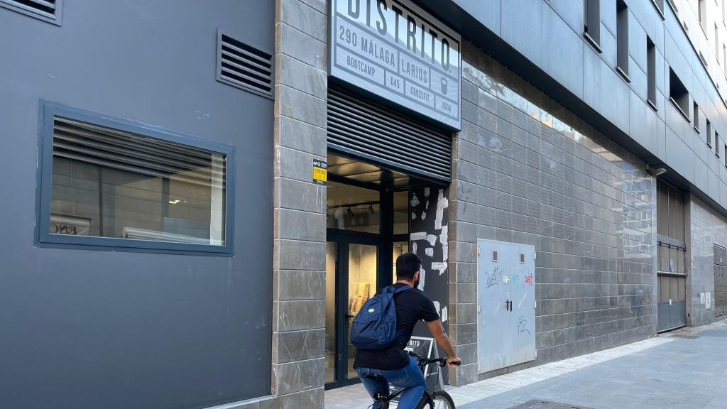 Un joven cruzando frente a Distrito Estudio con su bici.