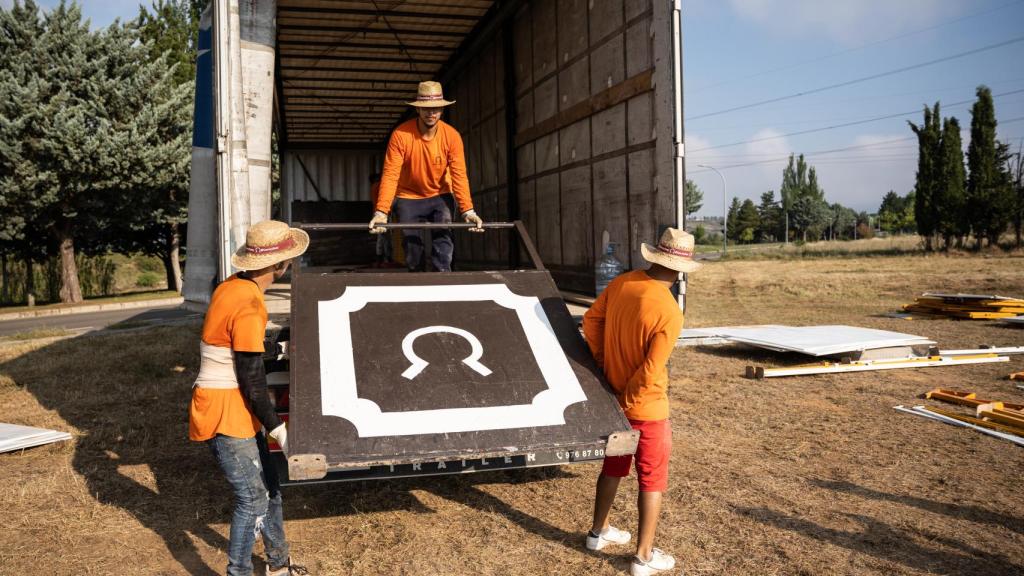 Los operarios descargan un camión a las 7 de la mañana.