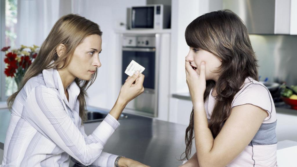 Madre dando un condón a su hija.
