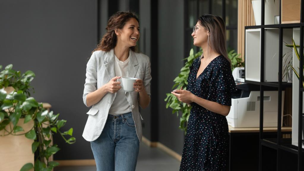Dos mujeres charlan en el trabajo.