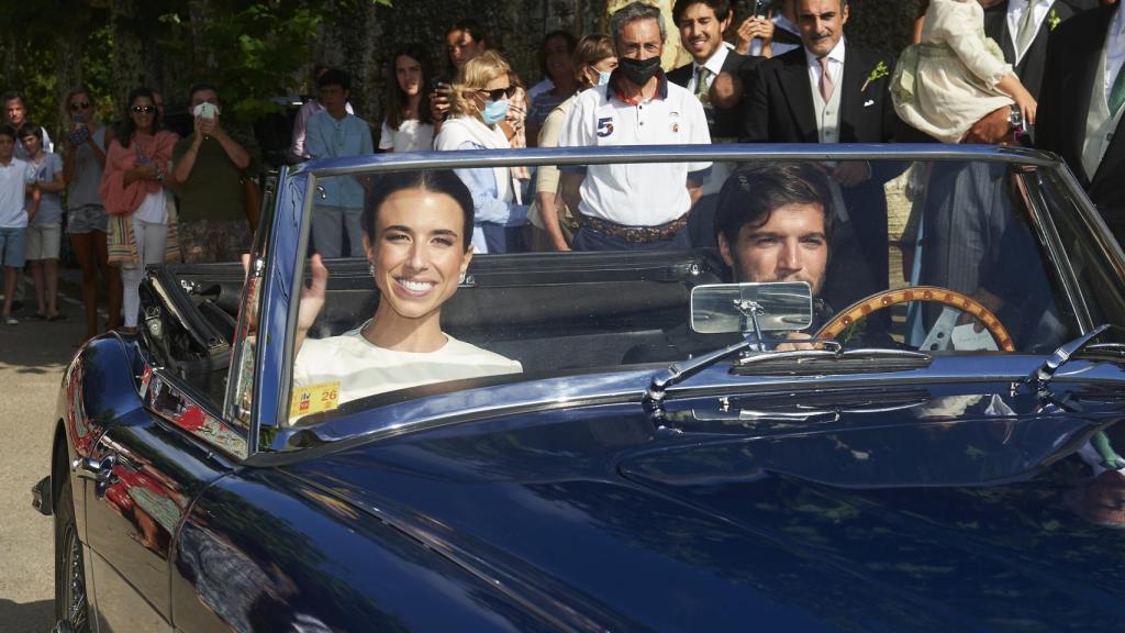 La pareja salió de la iglesia en un descapotable de color azul.