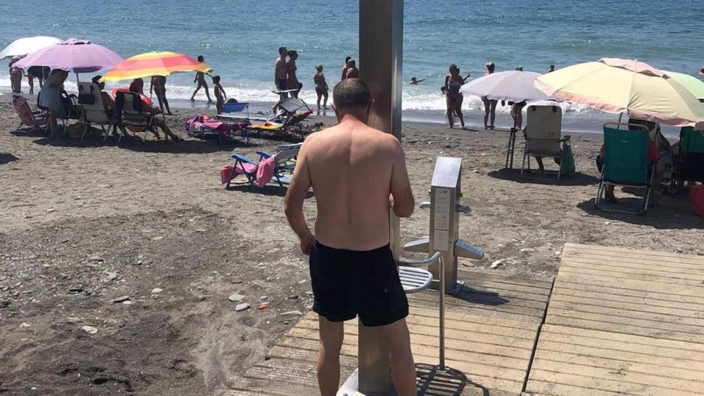 Un hombre usando una ducha en Algarrobo.