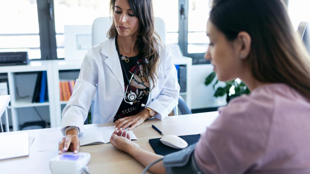 Una doctora comprueba la presión sanguínea de su paciente.