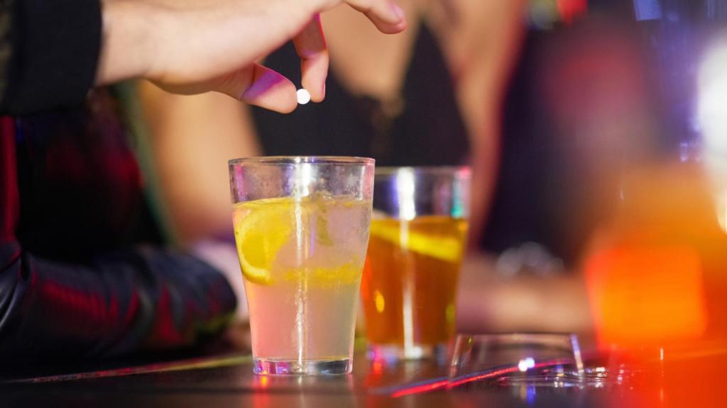 Imagen de archivo de un individuo que introduce una pastilla en un vaso en una discoteca.