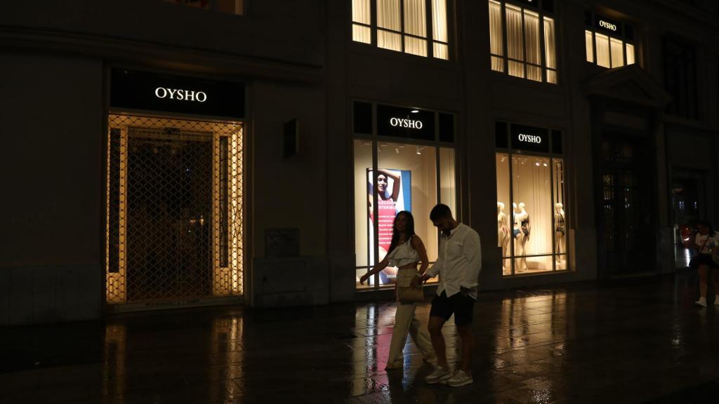 Varias personas caminan frente a un escaparate en Madrid.