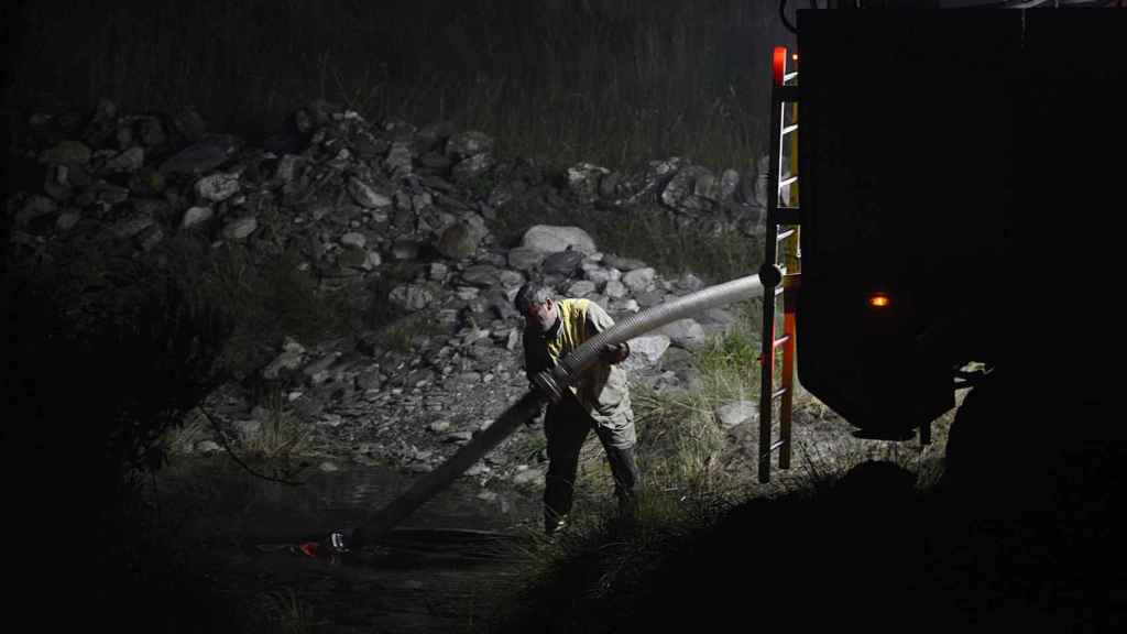 Conductor de motobomba carga el camión de agua desde el río Balboa en una foto de archivo.