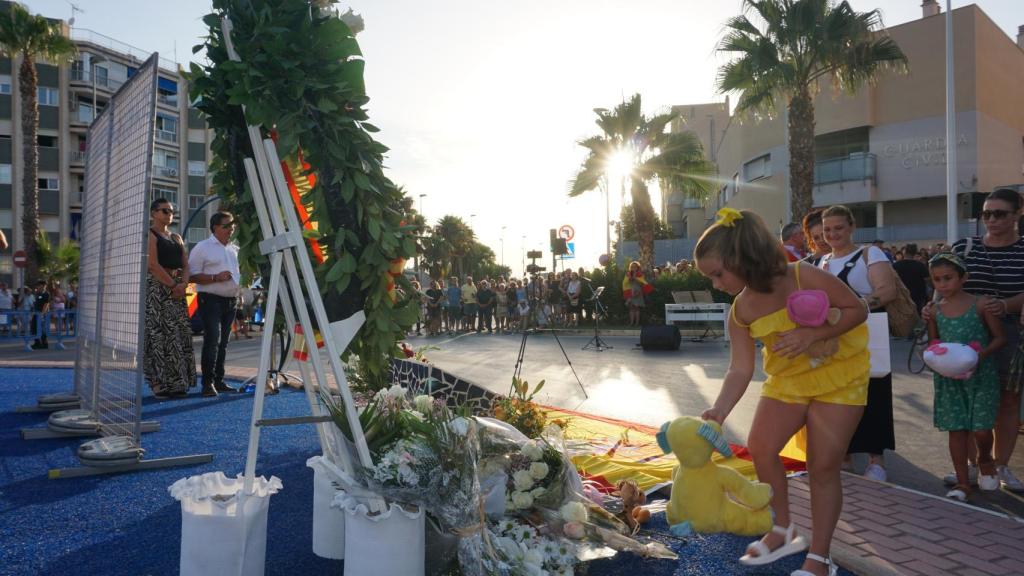 Una niña deja un peluche en la placa en recuerdo de Silvia Martínez.