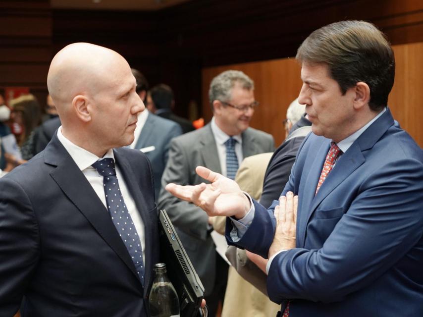 El presidente de la Junta, Alfonso Fernández Mañueco, y el portavoz de Vox, Carlos Menéndez, conversan en las Cortes.