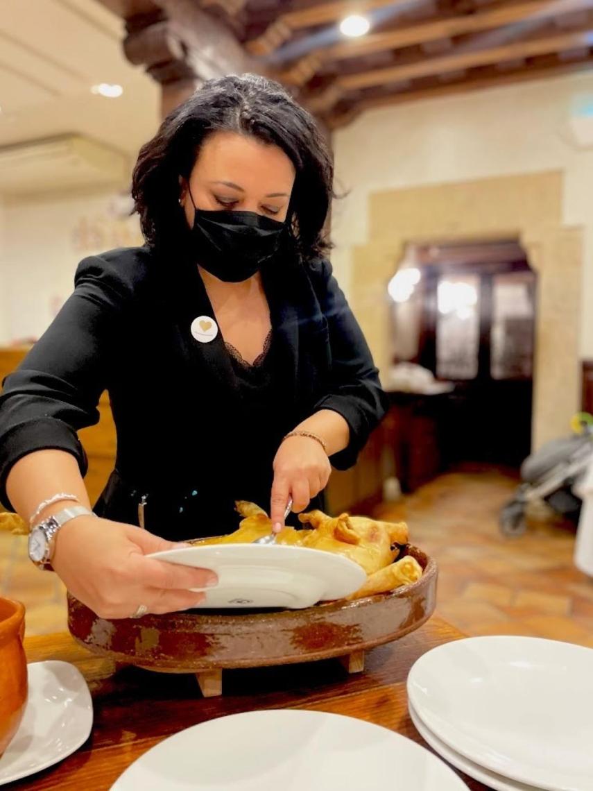 Rocío de Grupo José María preparando cochinillo asado en sala.