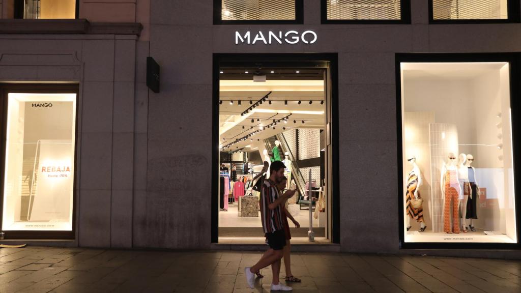 Varias personas en las puertas de una tienda, a 2 de agosto de 2022, en Madrid.