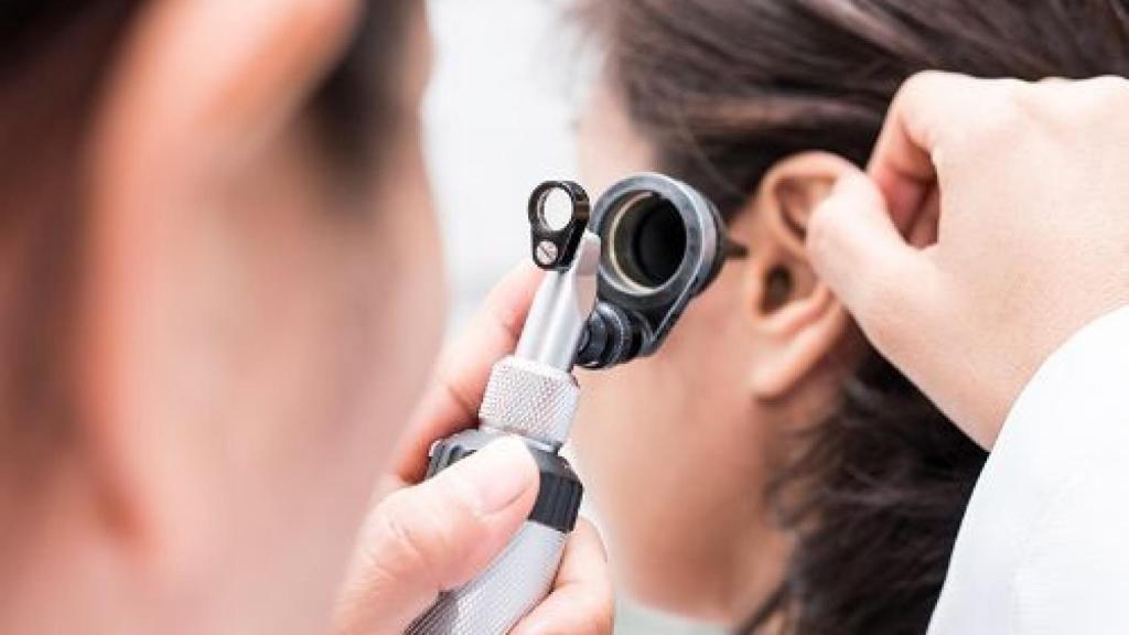 Una especialista explora el oído de una niña.