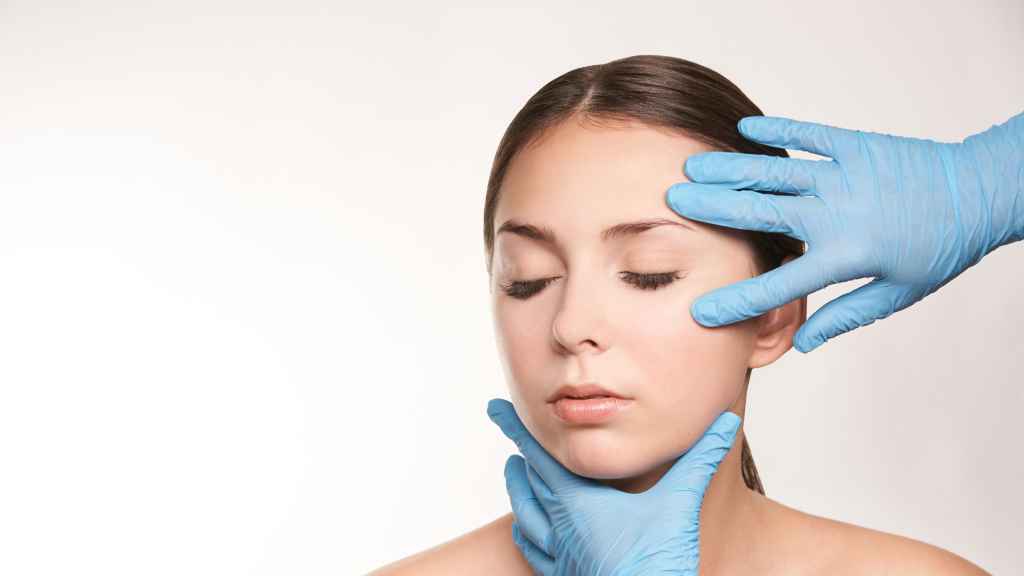 Una mujer en manos de su cirujano para hacerse una mentoplastia.