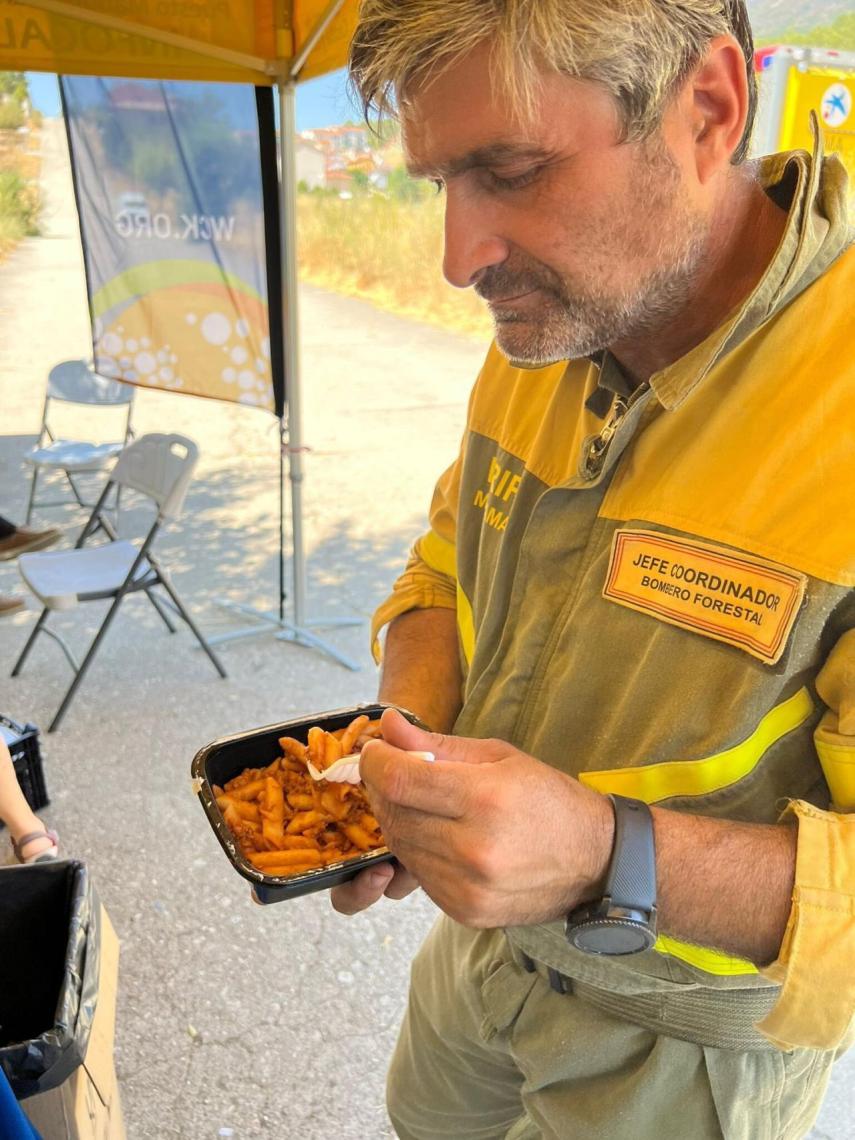 Un bombero comiendo macarrones