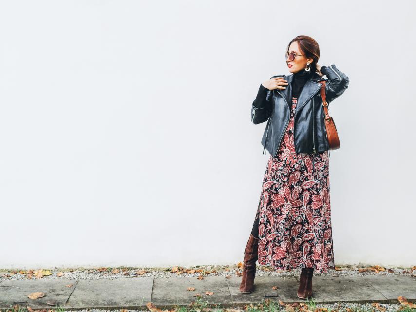 Una mujer luce una cazadora 'biker' y la combina con un vestido largo y unas botas.