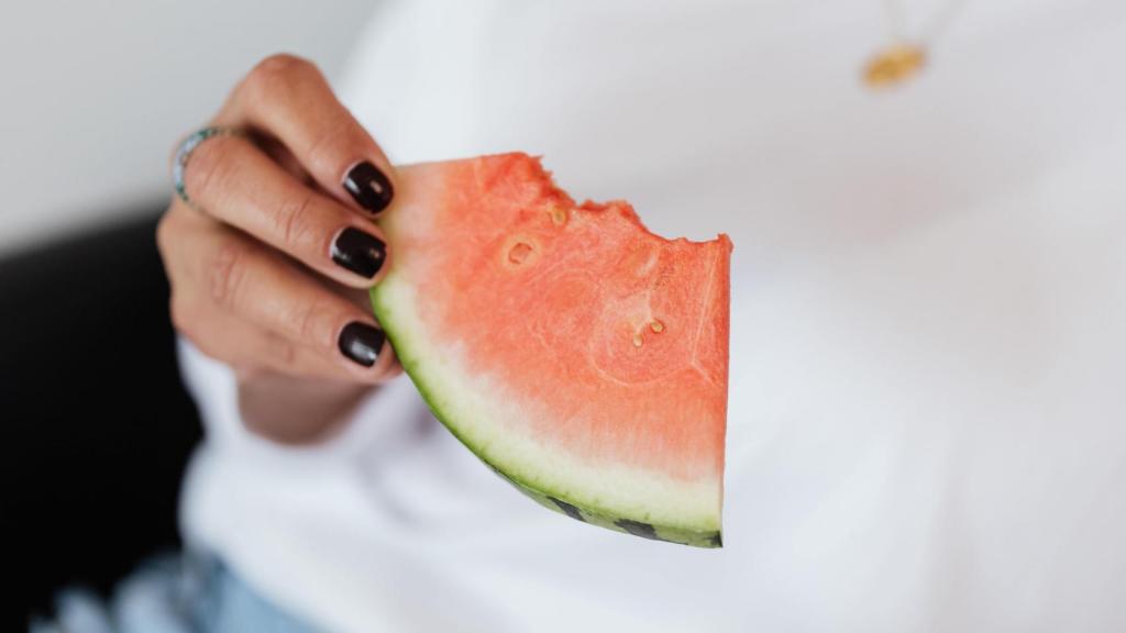 Una persona sujetando una sandía.