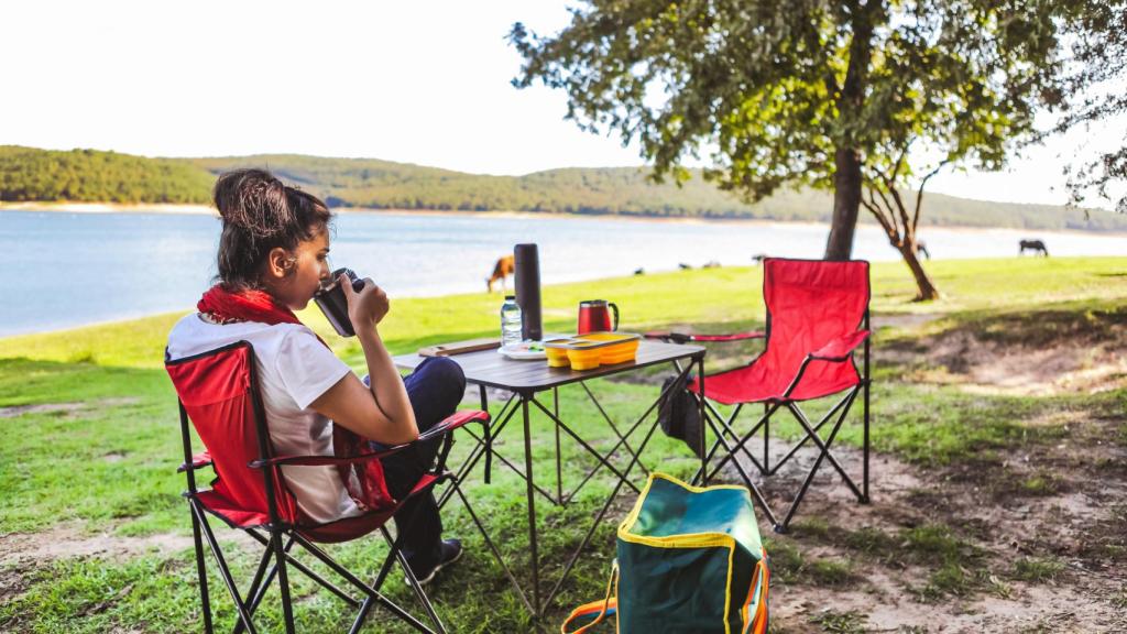 Mujer bebiendo café en un camping