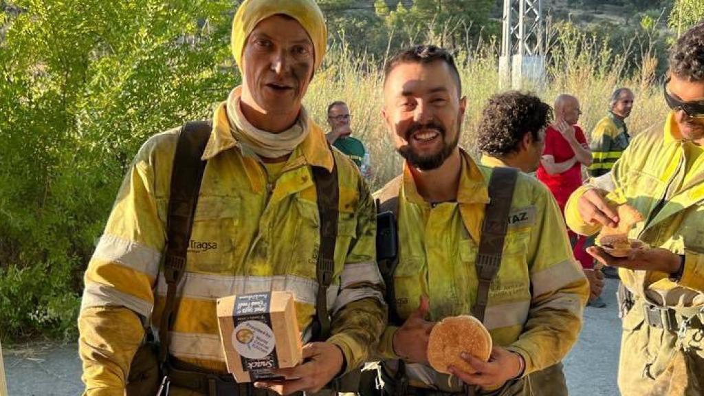 Bomberos forestales posan con la comida suministrada por la ONG