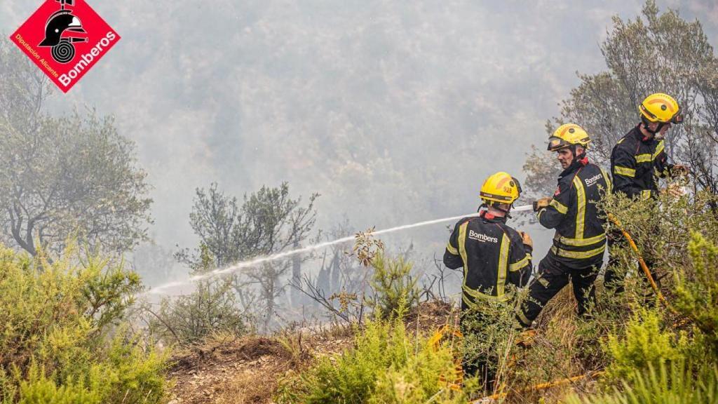Bomberos intentan apagar uno de los focos.