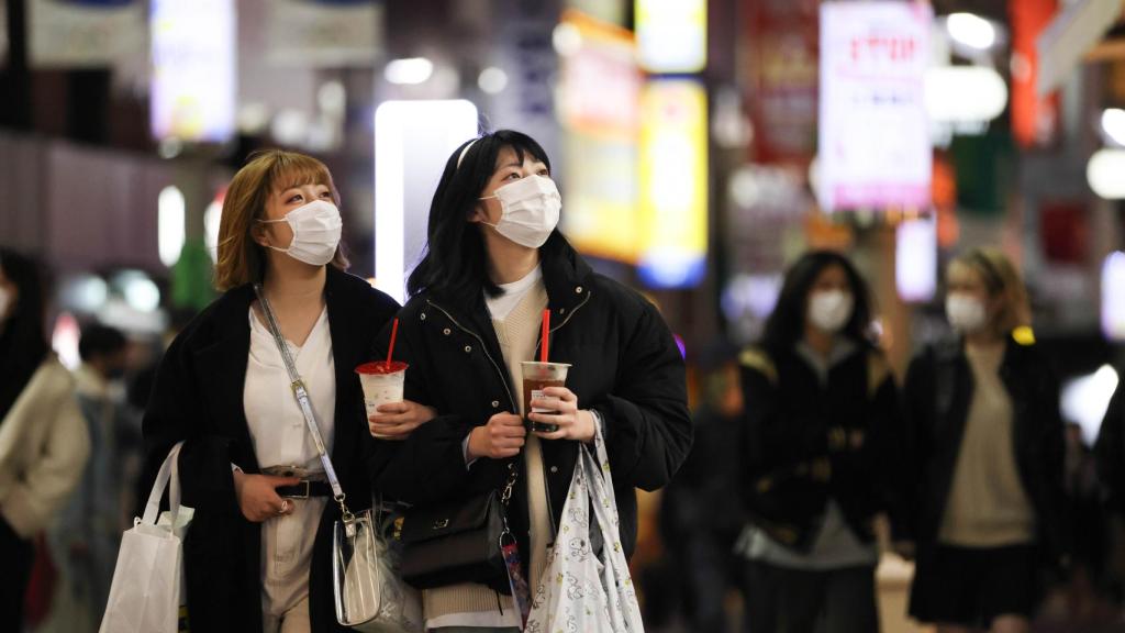 Dos jóvenes caminan por la calle en el distrito de Shibuya, en Tokio.