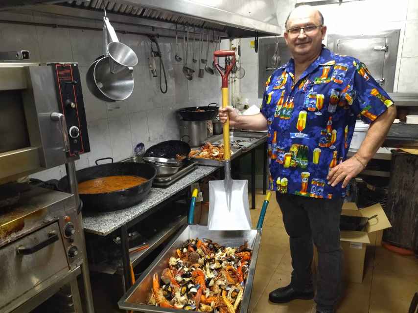 Pedro sirve en una carretilla y con una pala el marisco en su restaurante.
