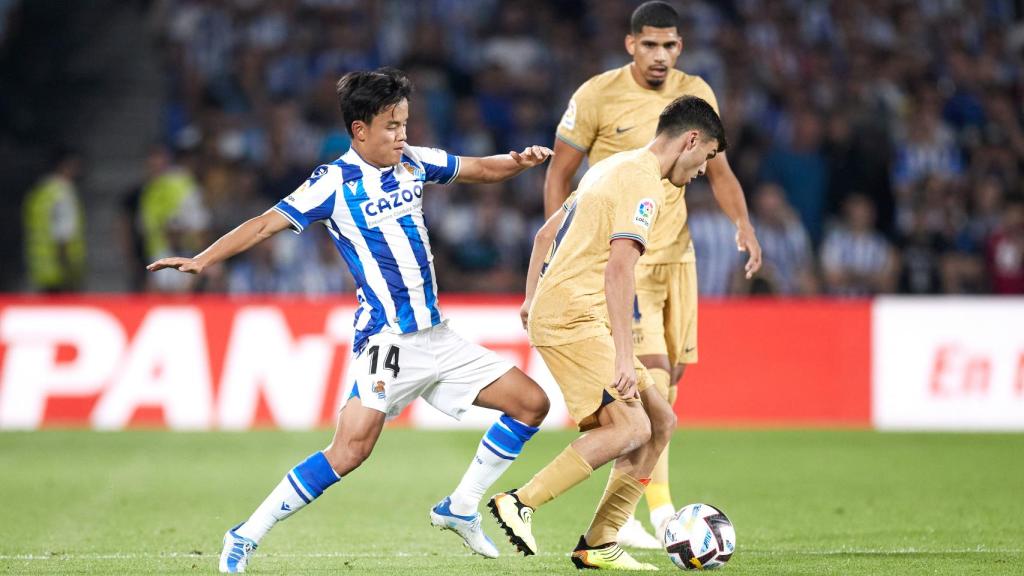 Pedri aguanta el balón ante la presión de Take Kubo