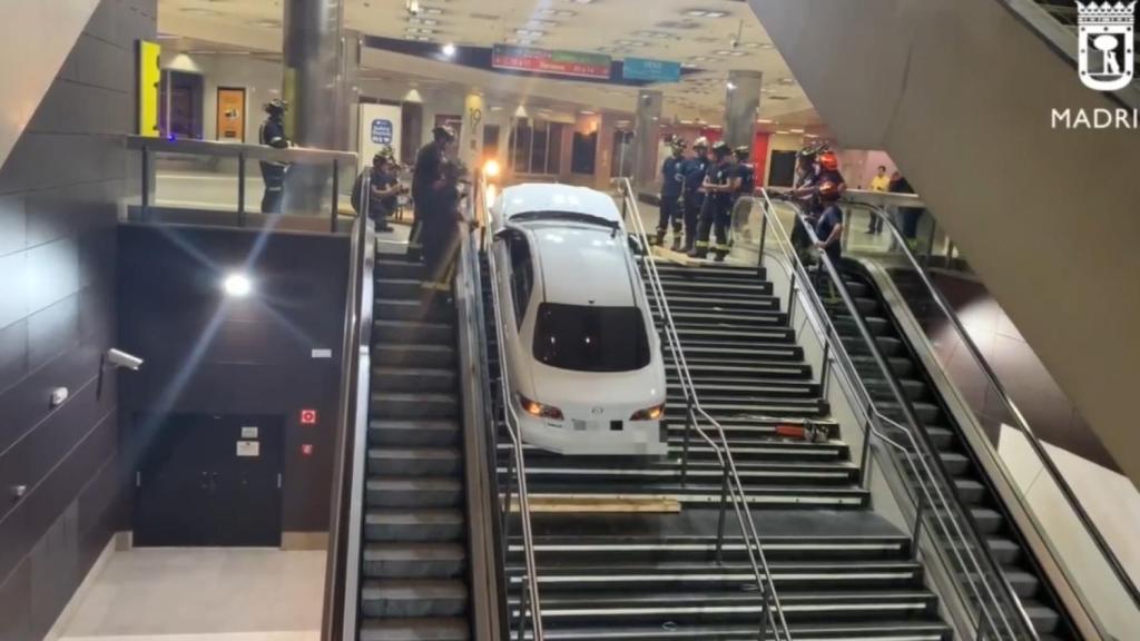 Bomberos del Ayuntamiento de Madrid retiran el coche encajado en las escaleras del intercambiador de Plaza Elíptica.