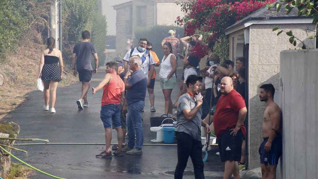 Los vecinos de la parroquia de Meira (Moaña) con cubos de agua y mangueras para sofocar el fuego.
