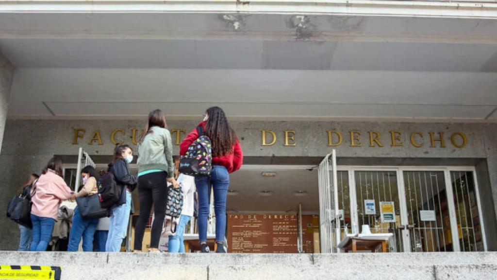 Varios estudiantes a las puertas de la facultad.