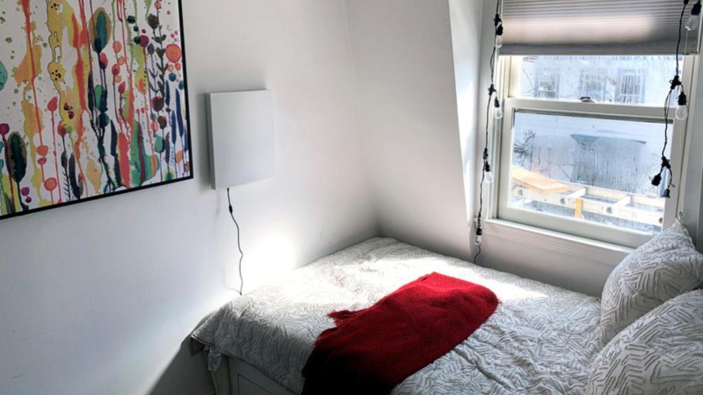 El dispositivo de color blanco con la IA colocado en la pared de un dormitorio.