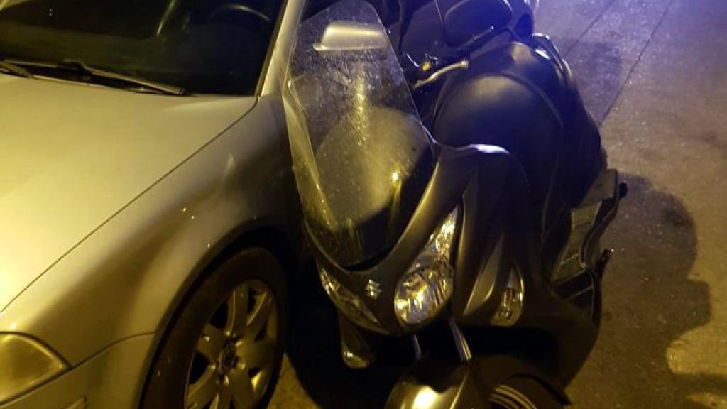 Moto volcada contra un coche.