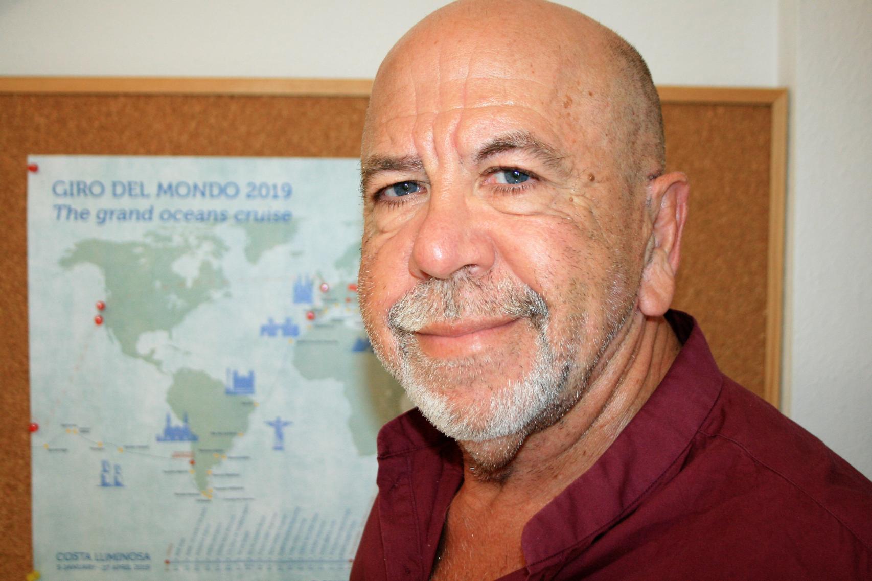 El crucerista Pedro J. González Fernández, junto a un mapa de su vuelta al mundo en barco.