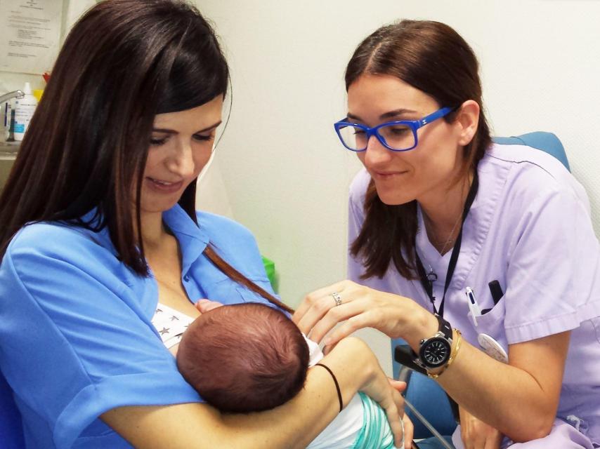 Una sanitaria ayuda a una madre a dar de mamar a su recién nacido.
