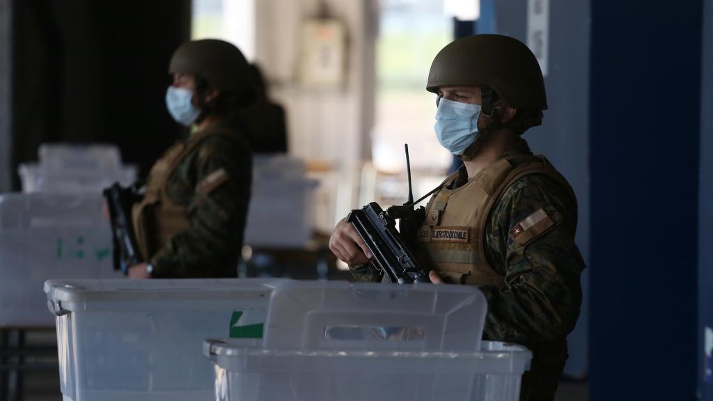 Unos militares chilenos custodian un colegio electoral.