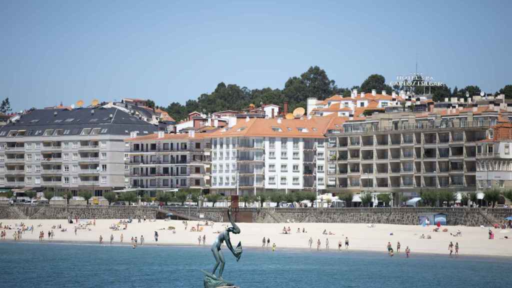 Varias personas disfrutan de la playa de Sanxenxo.