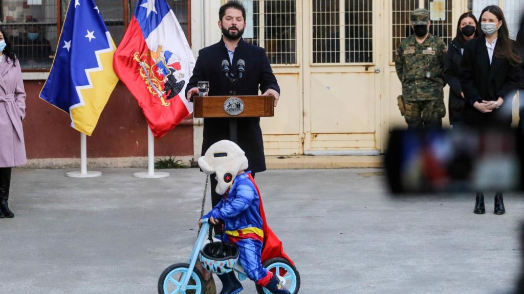 El niño vestido de Superman da vueltas alrededor de Boric.