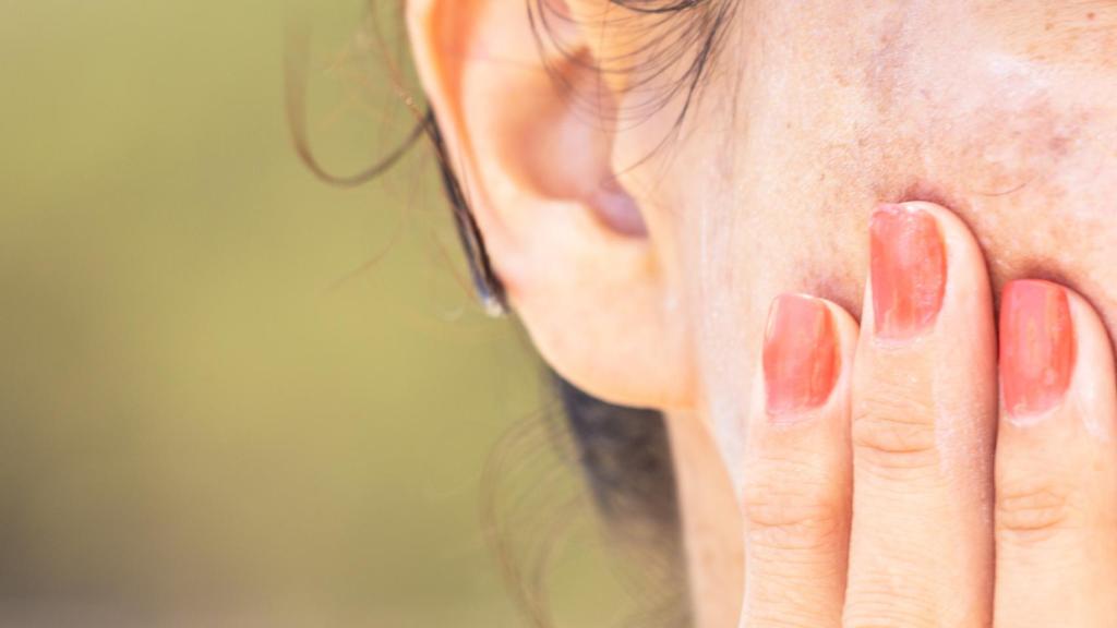 Una mujer se pone crema hidratante.
