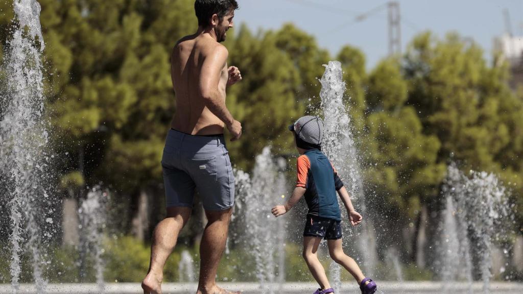 Dos personas refrescándose en una fuente de la Comunidad Valenciana