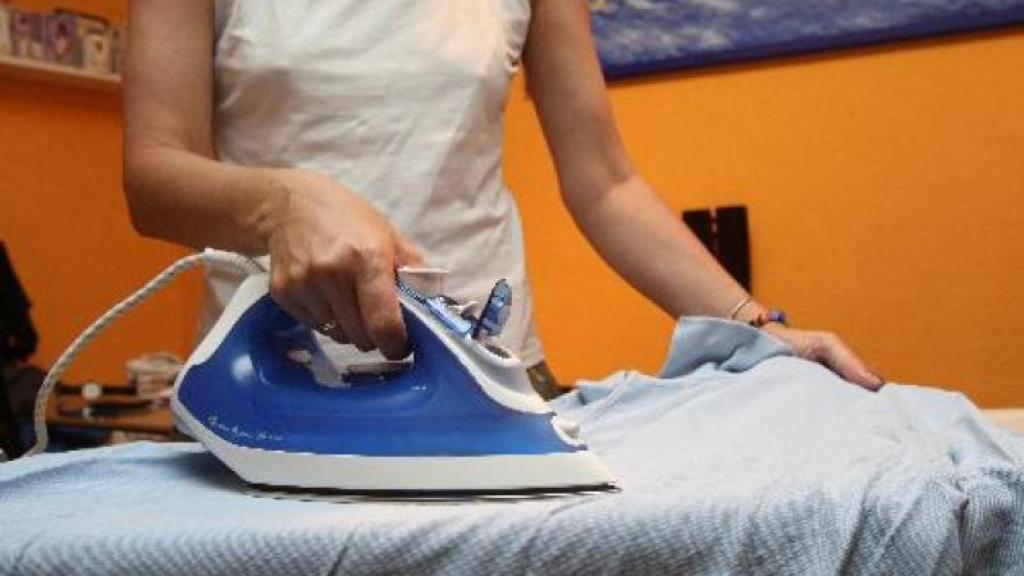 Una mujer, planchando.