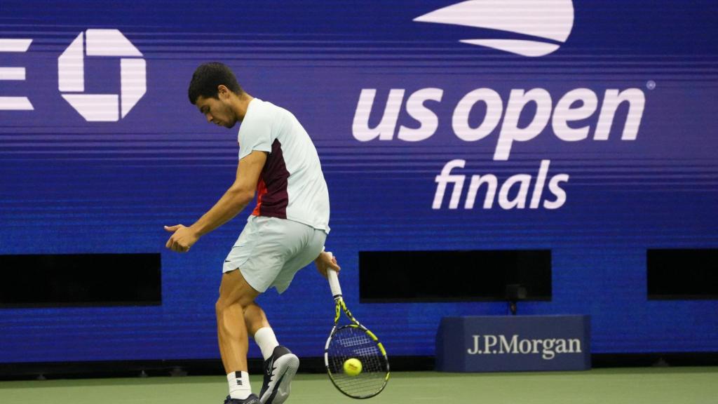 Carlos Alcaraz golpea a la bola de espaldas