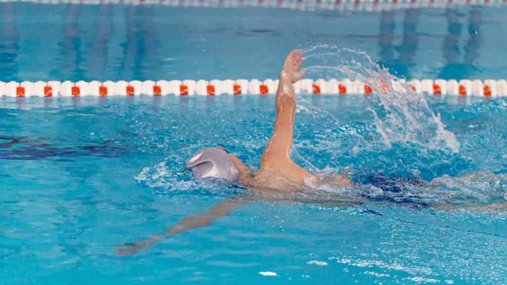 Niño practicando natación en una piscina climatizada.