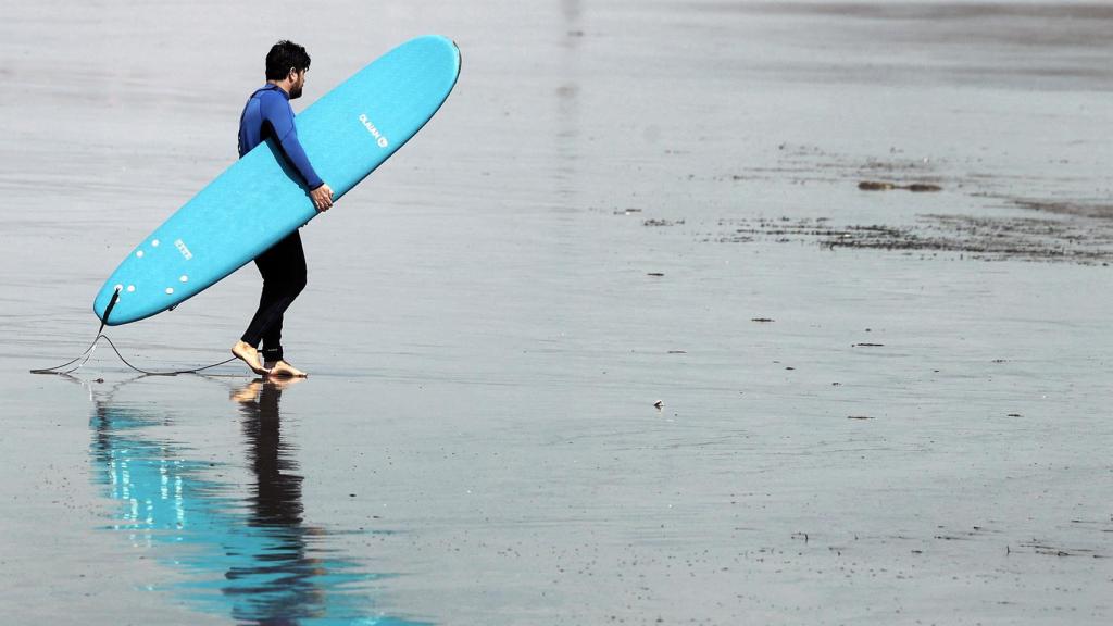 Una persona practicando surf en una playa valenciana, el pasado verano.