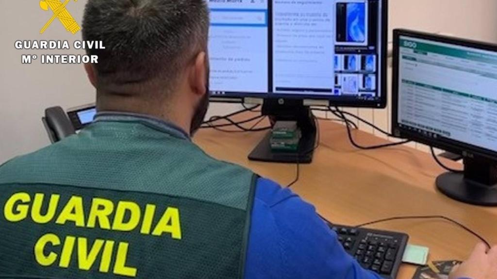 Un agente de la Guardia Civil trabaja frente a varias pantallas de ordenador.